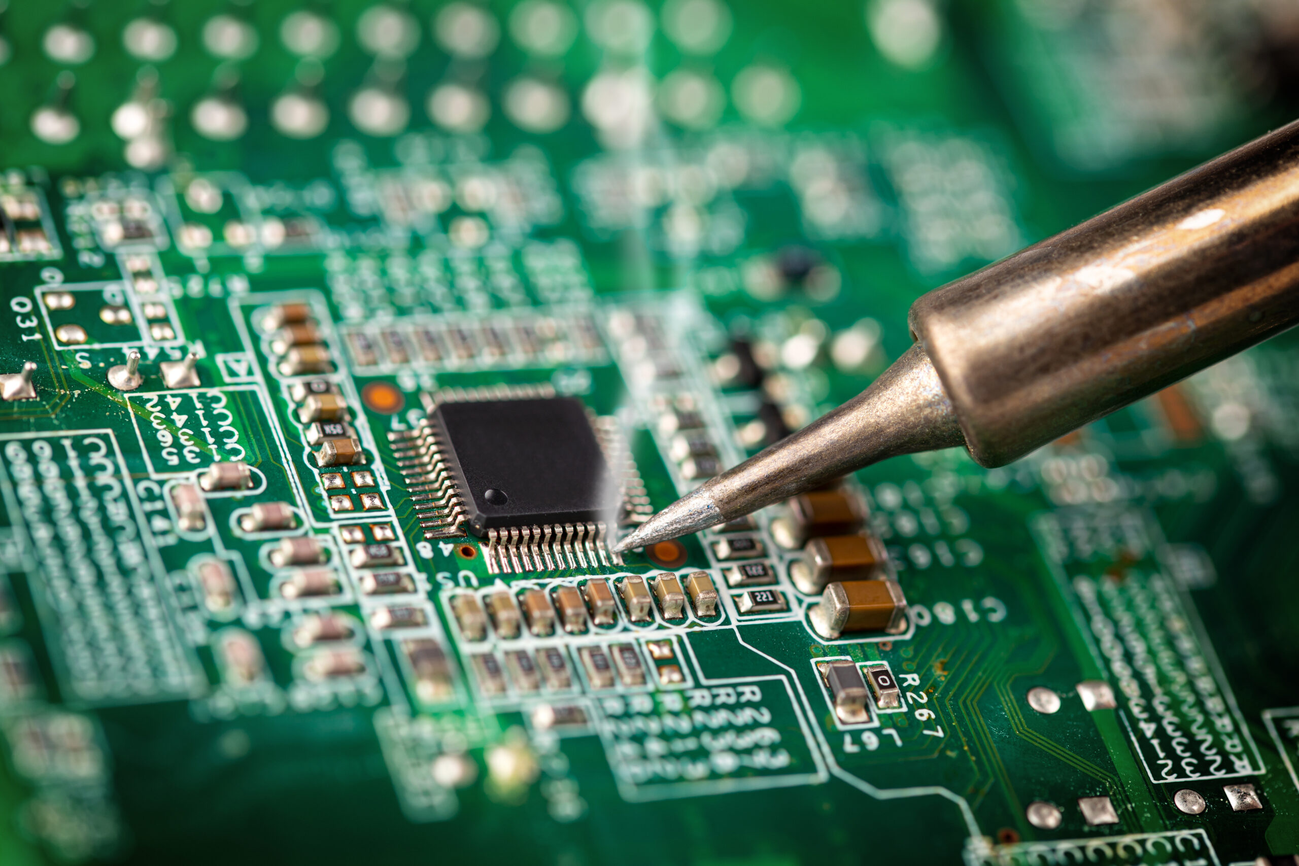 a tight macro of a soldering iron on a PCB.